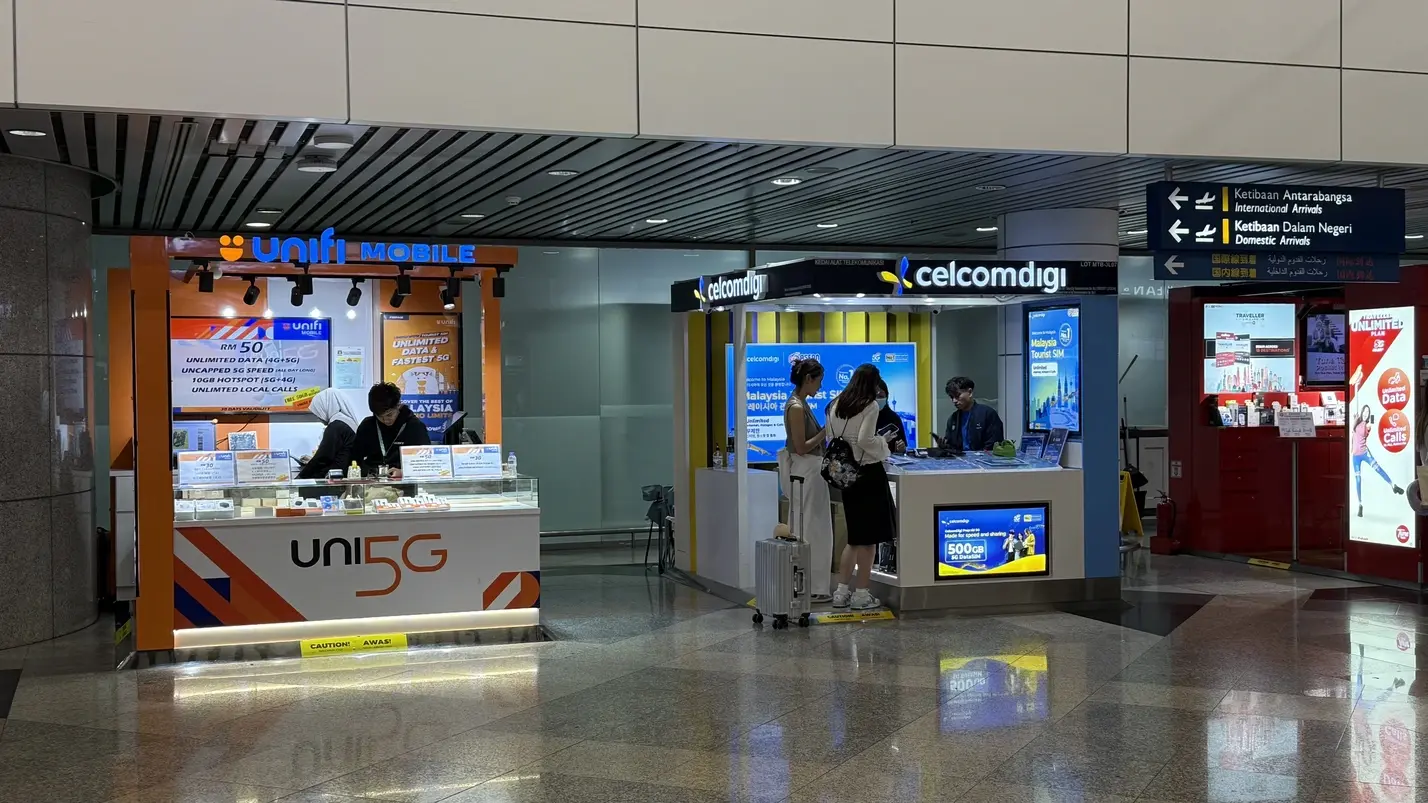 Mobile network booths for Unifi Mobile and CelcomDigi at Kuala Lumpur International Airport (KLIA1) arrivals hall